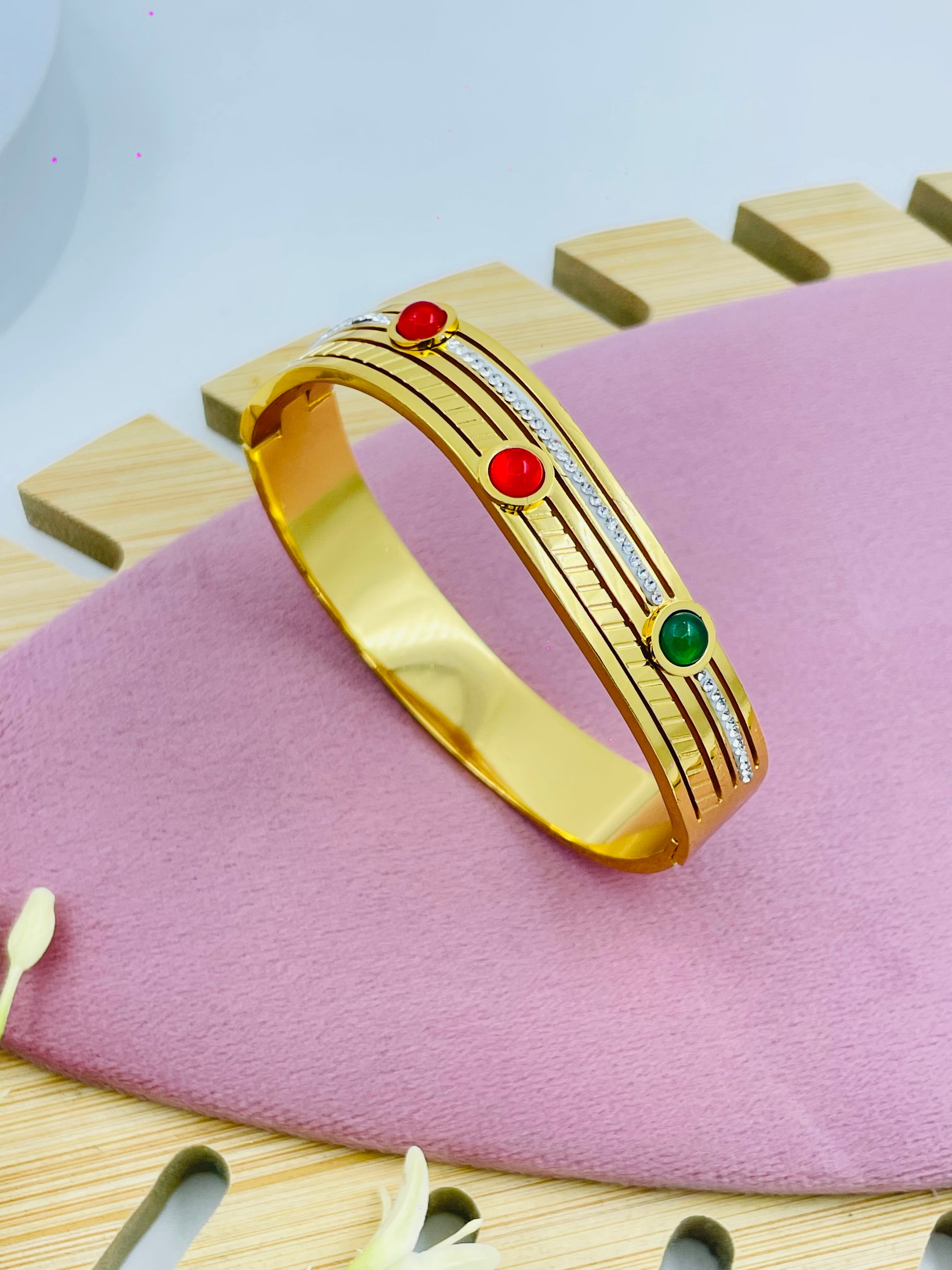 Elegant Gold Bangle with Red and Green Stones