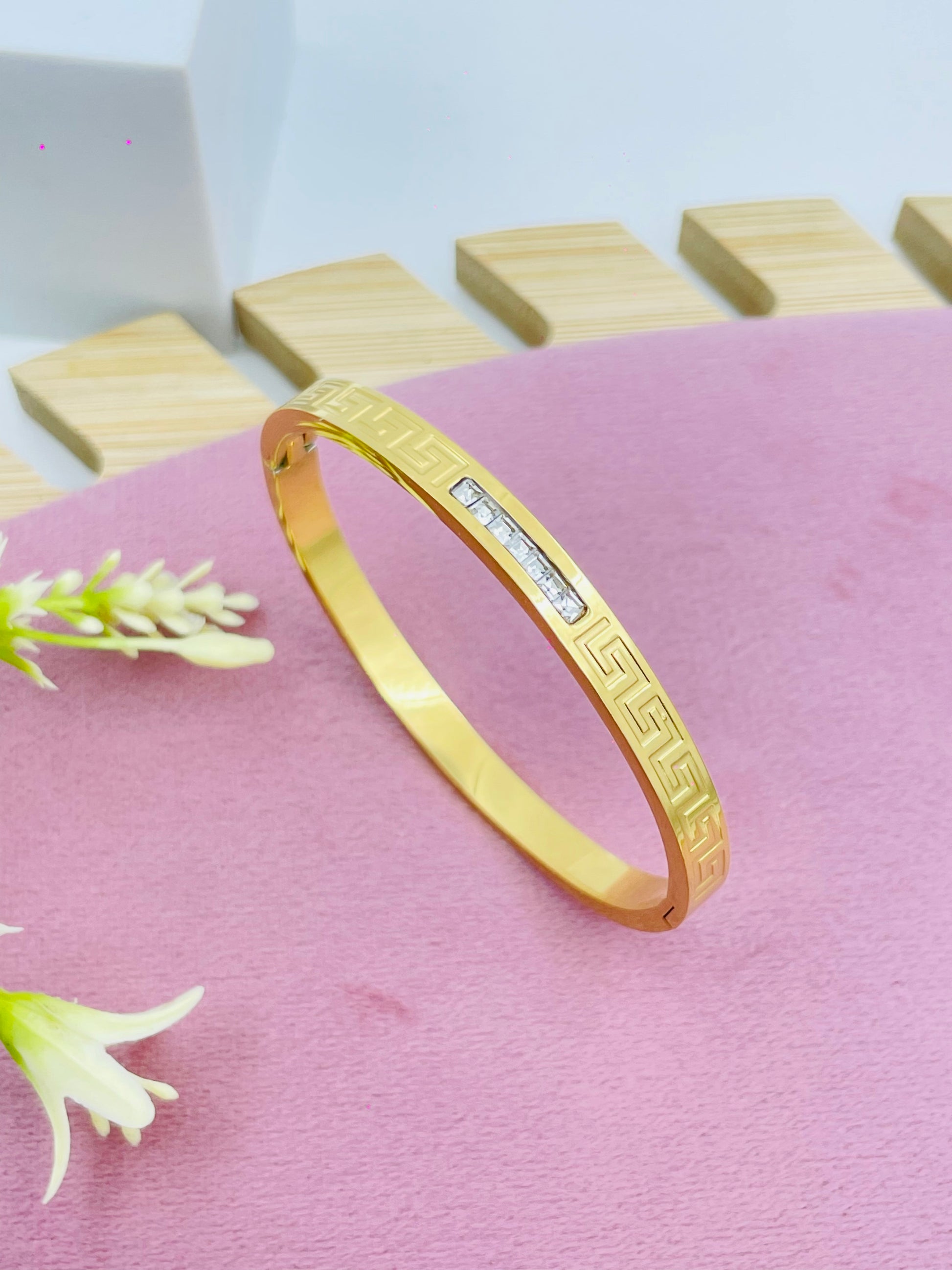 Elegant Gold Bangle with Geometric Design and Gemstone Accent